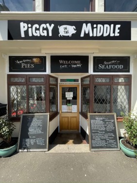 Fascia hand painted plus signs above the windows and door at Piggy in the Middle